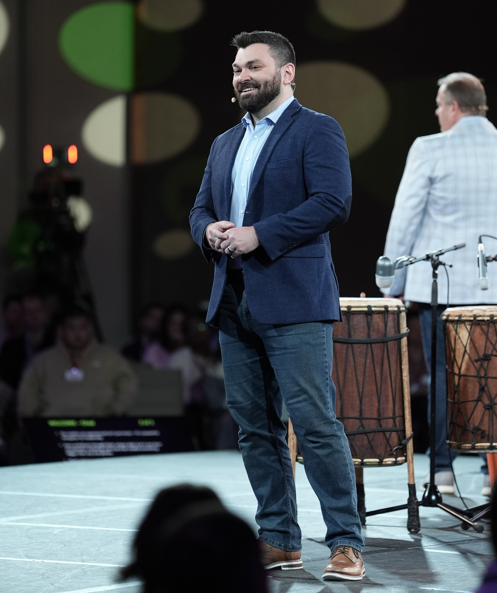Clif Mathews speaking on stage to a large audience